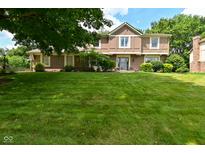 Traditional two-story home featuring a well-manicured lawn and lush landscaping in a suburban neighborhood at 4585 Abbey Dr, Carmel, IN 46033