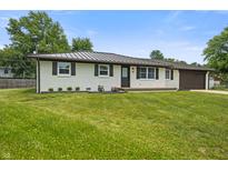 Exterior view of charming home with well-maintained lawn, mature trees, and updated roof at 6609 Cordova Ct, Indianapolis, IN 46221