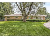Charming ranch-style home featuring a well-manicured lawn and mature landscaping in a serene setting at 7125 Chandler Dr, Indianapolis, IN 46217