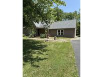 Charming brick home featuring a well-maintained lawn, mature trees, and decorative fountain, blending comfort with natural beauty at 9168 S State Road 9, Flat Rock, IN 47234
