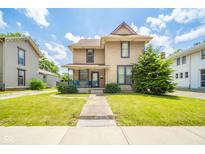 Charming two-story home with a covered front porch and well-maintained lawn at 917 W 8Th St, Anderson, IN 46016