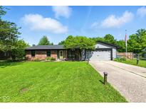 Charming single-story home featuring brick accents, an attached garage, and a well-maintained front yard at 9265 Brunson Run, Indianapolis, IN 46256