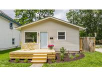 Charming home featuring a newly built deck with light blue door, and verdant landscaping at 946 N Temple Ave, Indianapolis, IN 46201