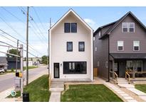 Modern two-story home with a white facade, black window frames, and a well-manicured lawn at 1100 English Ave, Indianapolis, IN 46203