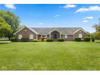 Spacious brick home with a well-maintained lawn and beautiful landscaping at 1439 E Mckenzie Rd, Greenfield, IN 46140