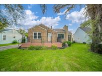 Charming stone-accented home featuring a cozy front porch and a well-maintained green lawn at 171 Nursery Rd, Anderson, IN 46012