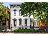 Charming two-story home with a beautifully landscaped front yard and an ornamental fence at 214 E St Joseph St, Indianapolis, IN 46202