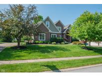 Charming brick two-story home featuring mature trees, lush landscaping, and a well-manicured lawn at 2901 Hazel Foster Dr, Carmel, IN 46033