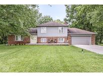 Charming home featuring a spacious lawn, a welcoming front porch, and an attached two-car garage at 3090 N County Road 800 E Rd, Brownsburg, IN 46112