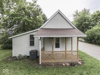 Charming home featuring a small porch and classic design, surrounded by lush greenery and mature trees at 3641 Harrison St, Needham, IN 46162