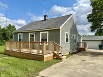 Charming home featuring a spacious front deck, well-maintained siding, and a detached garage at 405 E Cowing Dr, Muncie, IN 47303