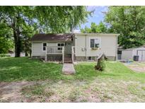 Charming single-Gathering home with a quaint front porch and walkway surrounded by mature trees at 4903 E Naomi St, Indianapolis, IN 46203