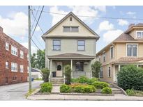Charming two-story home boasts manicured landscaping and inviting front porch at 519 Sutherland Ave, Indianapolis, IN 46205