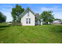 Quaint two-story white farmhouse with a green lawn and mature trees at 5396 N 1000 E, Sheridan, IN 46069