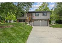 Charming two-story home featuring an attached two-car garage and a well-manicured front lawn with mature trees at 618 Shady Creek Dr, Greenwood, IN 46142