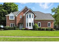 Beautiful brick two-story home with manicured lawn and mature trees at 6316 Harmonridge Ct, Indianapolis, IN 46278