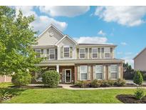 Charming two-story home with a brick and siding facade, lush landscaping, and a well-maintained front yard at 6622 W Dickens Xing, McCordsville, IN 46055