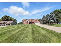 Charming brick ranch home with a well-manicured lawn and a long driveway leading to an attached two car garage at 8030 5 Points Rd, Indianapolis, IN 46259