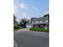 Charming two-story home boasts a lush front yard and long driveway leading to an attached garage at 922 Eagle Brook Dr, Shelbyville, IN 46176