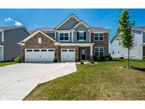Charming two-story home featuring a brick facade, gray siding, and a well-maintained front yard at 9407 Casey Rd, Pendleton, IN 46064