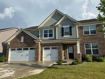 Charming two-story brick home featuring a three-car garage, manicured lawn and neutral colored siding at 9407 Casey Rd, Pendleton, IN 46064