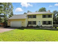 Charming two-story home featuring a well-maintained lawn, attached garage, and classic colonial architecture with black shutters at 1224 S Hunter Rd, Indianapolis, IN 46239