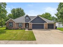 Charming single-story home featuring a well-manicured lawn, brick accents and a spacious three car garage at 12661 Doe Ln, Indianapolis, IN 46236