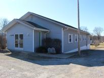 Well-maintained one-story building with light gray siding, and a gravel driveway at 1267 W 750 S, Trafalgar, IN 46181