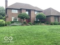 Beautiful brick home with a large front lawn and meticulously maintained landscaping at 1273 Helford Ln, Carmel, IN 46032