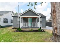 Charming single-story home showcasing a covered porch, gray siding, and a manicured lawn at 1504 Manhattan Ave, Indianapolis, IN 46241
