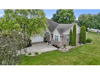 Charming home featuring a well-manicured lawn, brick accents, and a spacious driveway leading to an attached garage at 15098 Newburyport Dr, Fortville, IN 46040