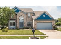 Charming two-story home with a well-manicured lawn, a gray two-car garage and brick facade at 1521 Midnight Pass, Brownsburg, IN 46112