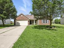 Charming brick home with a two-car garage and a well-maintained lawn at 1702 Juniper Ln, Greenwood, IN 46143