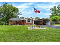 Charming single-story brick home featuring a lush green lawn and American flag at 3038 S Richardt Ave, Indianapolis, IN 46239