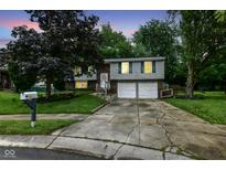 Charming two-story home with a two-car garage, gray siding, brick facade, and well manicured lawn at 317 Heritage Ct, Fishers, IN 46038