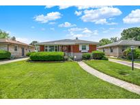 Charming brick ranch-style home with a well-manicured lawn and mature landscaping under a bright sky at 3322 N Riley N Ave, Indianapolis, IN 46218