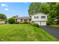 Charming split-level home featuring a brick facade, a two-car garage, and lush landscaping at 3388 S Leonard Rd, New Palestine, IN 46163