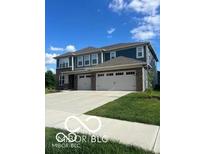 Modern two-story duplex featuring double garages, well-maintained lawns, and a concrete driveway under a sunny blue sky at 3609 Merchmont Rd, Bargersville, IN 46106