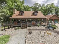 Charming log home with a spacious wraparound porch and beautifully landscaped yard with a water fountain at 5240 W 400 N, Fairland, IN 46126