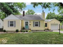 Charming yellow home with gray trim, landscaped yard, and a pop of color on the front door at 5378 Rosslyn Ave, Indianapolis, IN 46220
