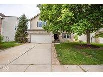Two story home with brick facade and a two-car garage with mature landscaping and nice front yard at 6532 Amherst Way, Zionsville, IN 46077