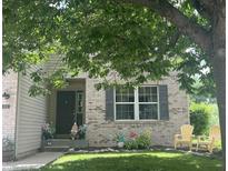 Charming brick home with well-maintained lawn, mature tree, and cheerful decorative details at 6532 Amherst Way, Zionsville, IN 46077