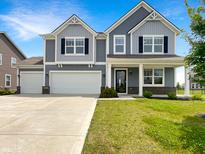 Charming two-story home featuring a two-car garage, a well-manicured lawn, and classic curb appeal at 6933 Sonora Blvd, Clermont, IN 46234