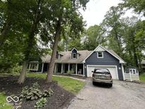 Charming home features a two car garage, mature trees, and a cozy front porch at 8407 Campbell Ct, Mooresville, IN 46158
