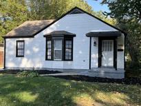 Charming home featuring white siding, black trim and bay window at 937 N Routiers Ave, Indianapolis, IN 46219