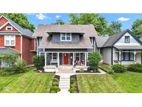 Charming two-story home with a welcoming front porch, steps, and colorful landscaping at 1105 Windsor St, Indianapolis, IN 46201
