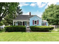 Charming blue home with red shutters and a well-manicured lawn at 114 South St, Southport, IN 46227
