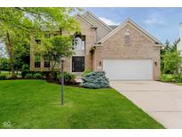 Beautiful brick home featuring a well-manicured lawn and lovely landscaping at 12490 Windbush Way, Carmel, IN 46033