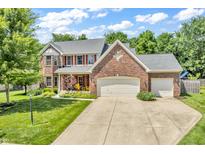 Charming two-story brick home featuring a well-manicured lawn, two-car garage, and inviting front porch at 15075 Windsor Ln, Noblesville, IN 46060