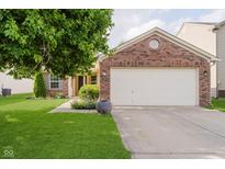 Brick home with a two-car garage, well-manicured lawn, and mature tree in the front yard at 16629 Greensboro Dr, Westfield, IN 46074